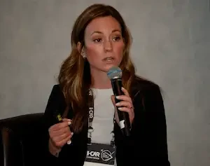 Kena Dacus speaking in a microphone