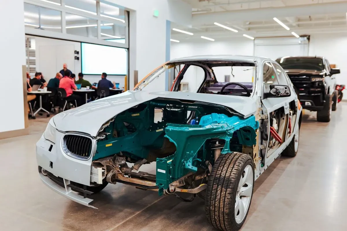 A cutaway training vehicle exposes structural members and internal components for collision training.