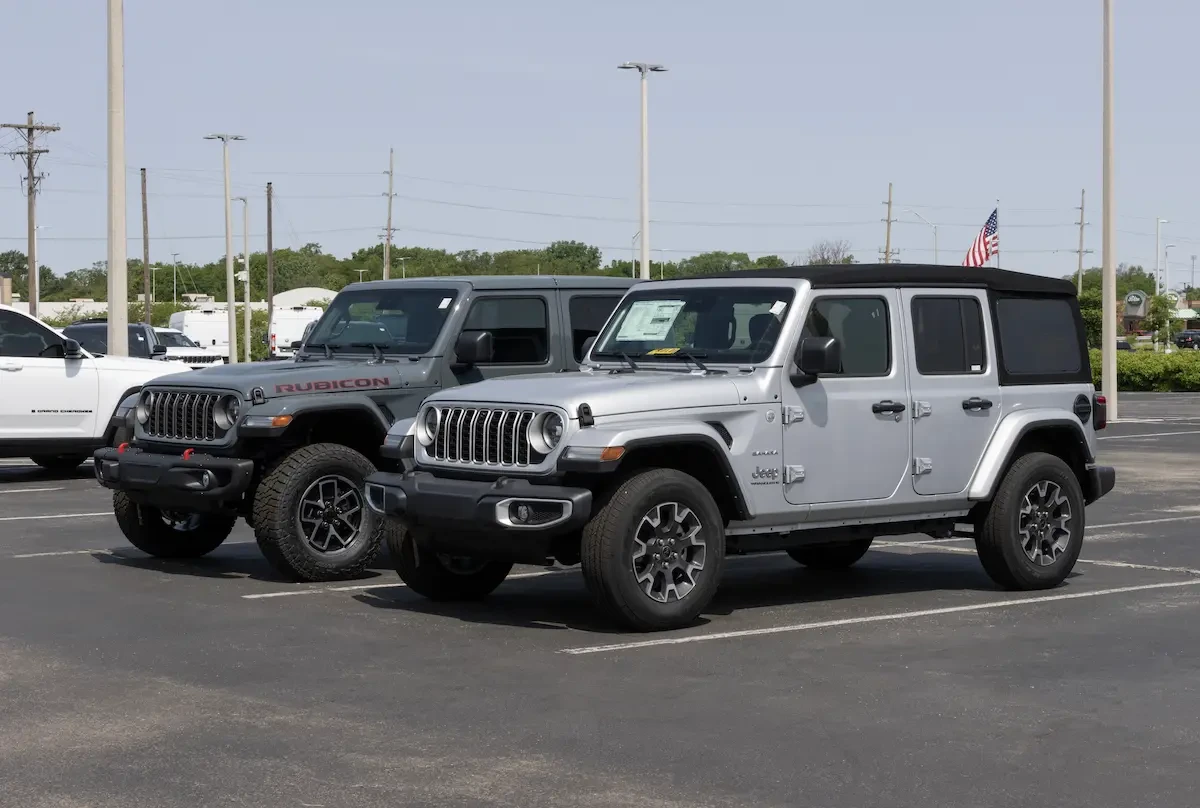 A gray Jeep Gladiator and a silver Jeep Wrangler parked side by side on a car dealership lot.