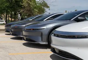 Row of gray and white Lucid Air sedans parked front-end facing forward in a parking lot