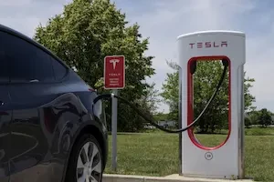 Dark colored Tesla plugged into a Tesla charger