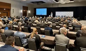 attendees watching speakers in a large room