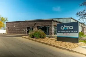 front view of a brown collision shop building 