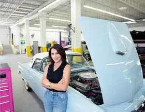 woman standing in front of car arms cross, hood open on car