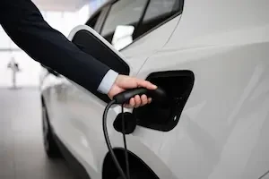 hand placing a charger in an electric car