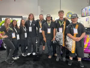 teacher and students standing together dressed in black 