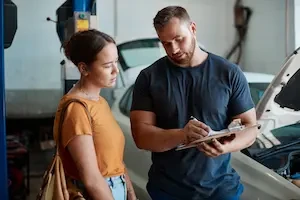 man showing a woman something on a clipboard
