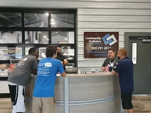 Collision shop workers standing by a front desk