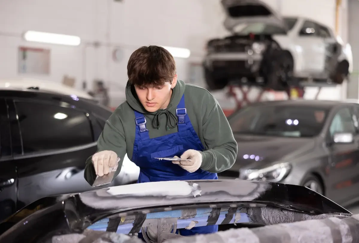 young auto technician working on a car