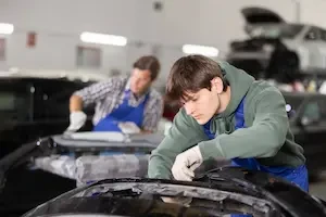 young auto technician working on a car