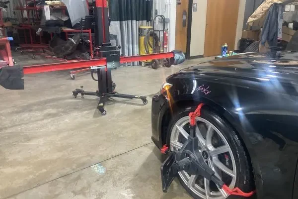 Autel SPS IA 700 Stand sitting in front of a car in a repair bay