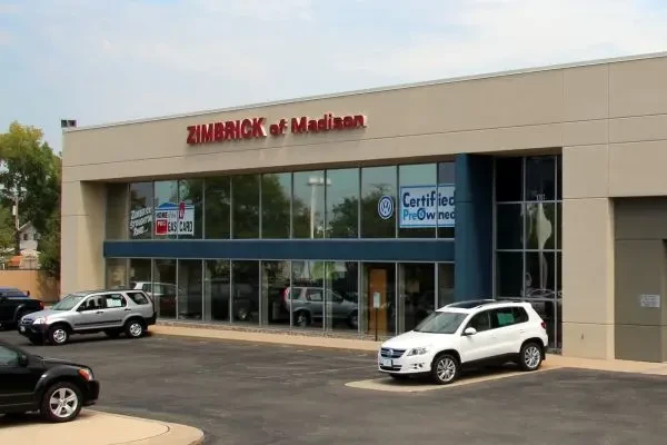 White rectangular building with Zimbrick of Madison on the front, three cars parked in front of it