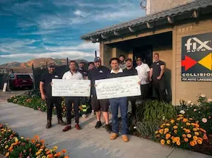 Fix Auto Lakeside workers holding two big checks