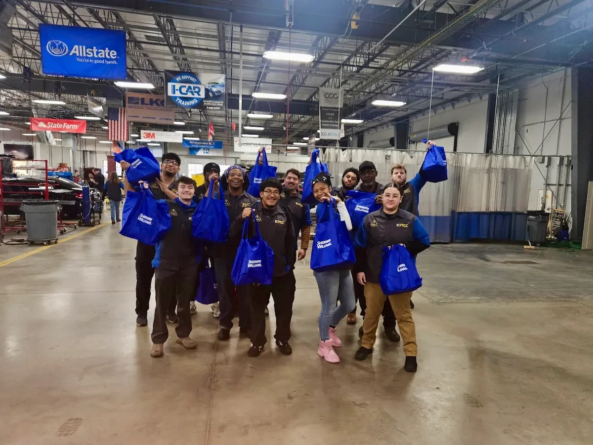Sherwin-Williams employees holding blue bags
