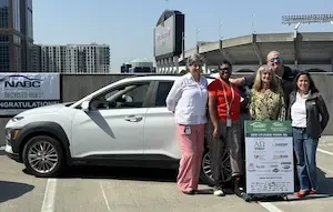 VGroup of people standing in front of a white SUV