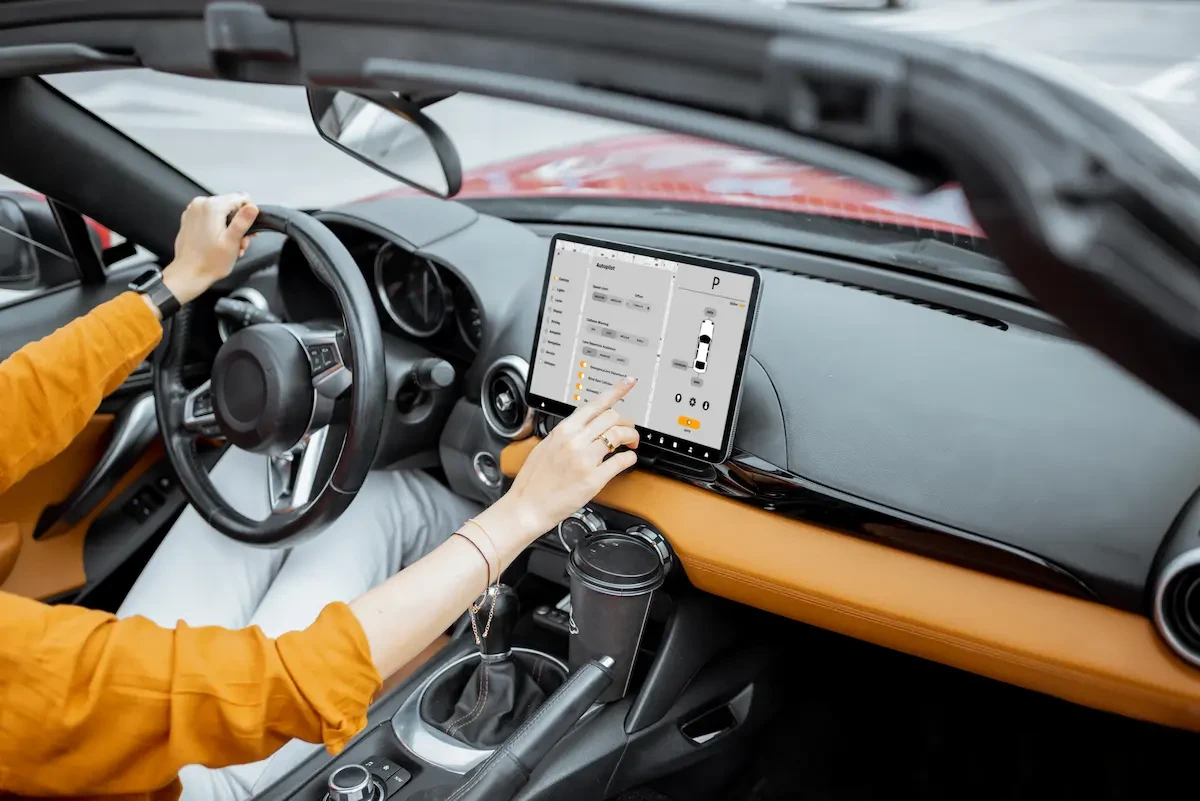 inside of a car with a driver operating a screen