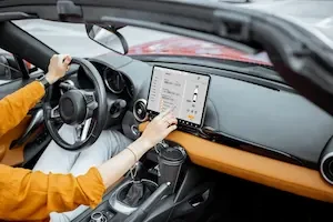 inside of a car with a driver operating a screen