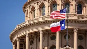 The Texas State Capitol with an American Flag and a Texas flag