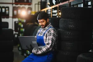 man on a computer with tires behind him 