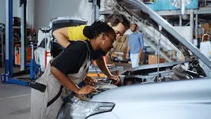two collision repair techs working on a car