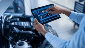 person holding tablet in front of a open hood