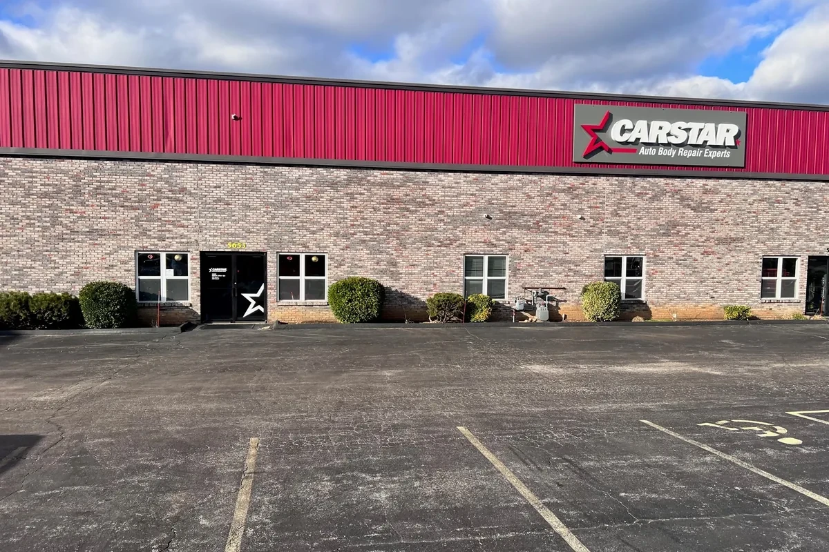 Tan brick building with red roof and CARSTAR sign on the exterior