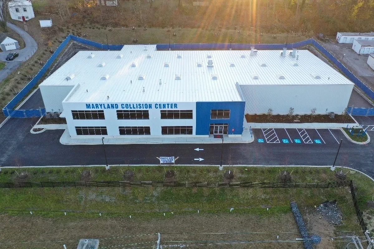 White building with blue accents and sign that says Maryland Collision Center
