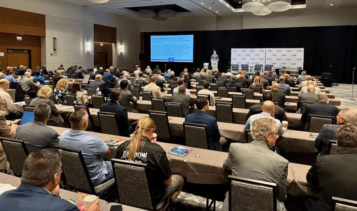 attendees watching speakers in a large room