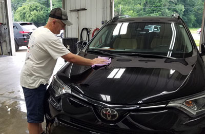 man-wiping-off-car-hood