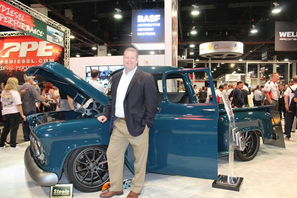 Chris Toomey, SVP of BASF Coatings, standing at the BASF Automotive Refinish Coatings booth at the SEMA Show with the 1957 Chevy Montage.