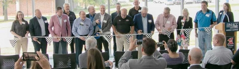 A racing-themed black and white checkered ribbon is cut during a ceremony for the recently renovated and expansion of the DMACC Ankeny Campus Automotive Center.