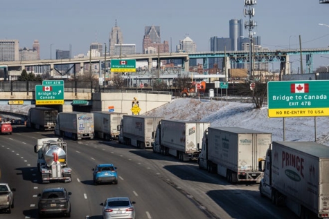 A small line of semi-trailer trucks line up along northbound Interstate 75 in Detroit as the Ambassador Bridge entrance is blocked off for travel to Canada on Feb. 8.