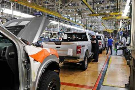 In this Sept. 27, 2018, file photo, United Auto Workers assemblymen work on 2018 Ford F-150 trucks being assembled at the Ford Rouge assembly plant in Dearborn, MI. Ford is suspending its dividend to preserve cash as vehicles sales fade due to the coronavirus outbreak