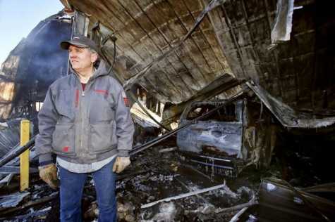 Mike Garrison, owner of High Torque Racing Auto Body and Paint Inc. in Meriden, KS, stands near a handicap van his shop had been working on before a fire the morning of Feb. 7 that burned the building to the ground. Rare and classic cars parked inside also were destroyed. 