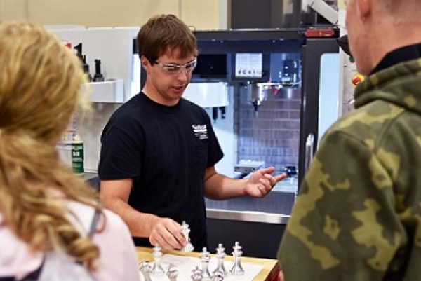 Jadon Wagner, a diversified manufacturing technology student from Winside, sets aside an aluminum chess piece crafted by the computer numerical control (CNC) machine behind him at Northeast Community College. Wagner was among Northeast students showcasing the College’s Applied Technology Division during a recent Career Day for high school students. 