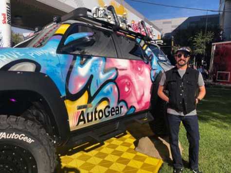 Robin Adkison, also known as “Robin1000,” a street artisan turned custom vehicle painter, stands with this year’s AutoNation theme truck.