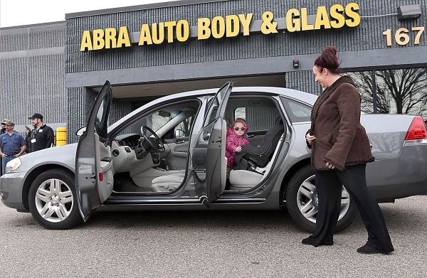 Shannon Pierce and her daughter Jola, 2, check out their new car Monday, Nov. 20, at Jerry’s Abra Auto Body &amp; Glass. Pierce later said her drive home to Granada was toasty warm and Jola did not want to get out of her new car seat, which, like their vehicle, was donated to the family. 